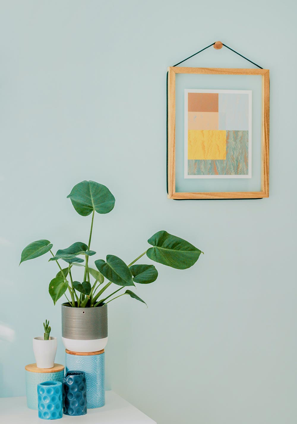 Green living room wall with plant on side table